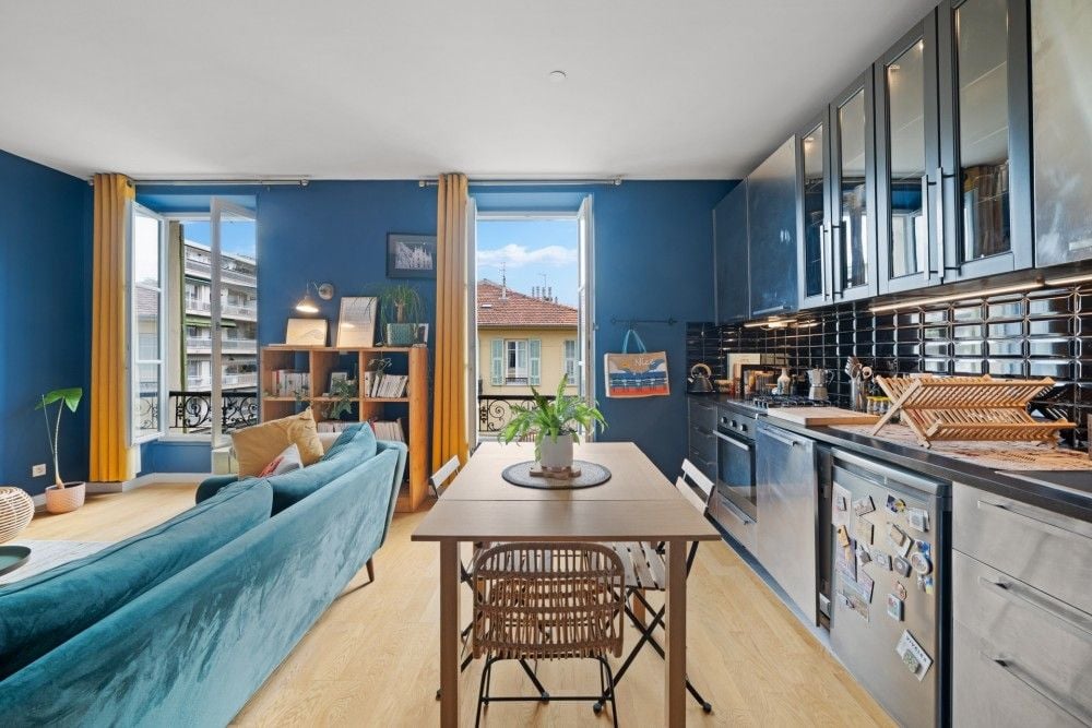 Living room and kitchen with deep blue walls and tall windows, 1-bedroom apartment in the Port, Nice