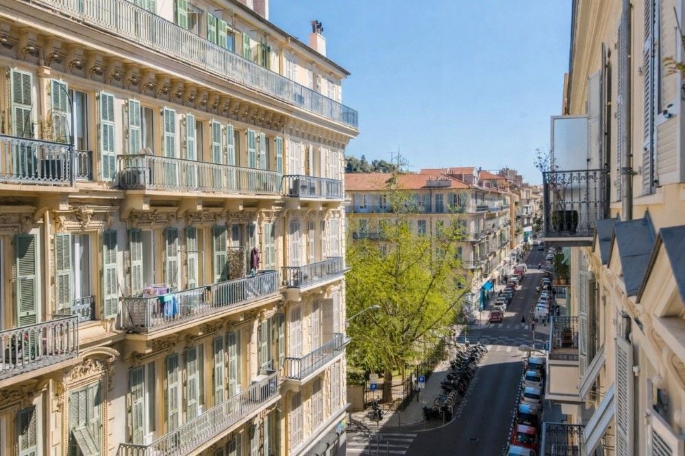 Balcony view down a tree-lined street of Belle Époque buildings, 4-bedroom apartment in central Nice