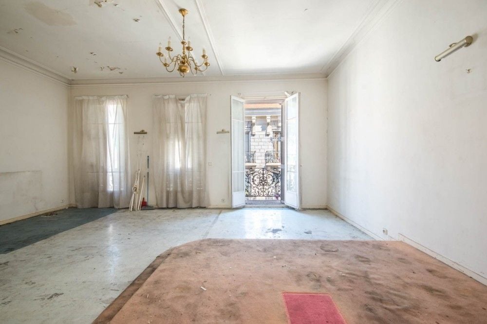 Large room with chandelier and French window to a balcony, to renovate, 4-bedroom apartment in central Nice