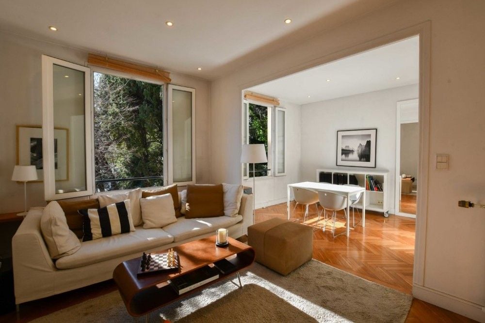 Living room with herringbone parquet and windows onto trees, 1-bedroom apartment in the Port, Nice