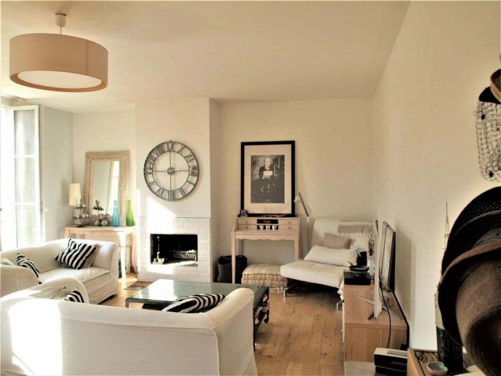 Living room with fireplace, white sofas and oak floor, 2-bedroom apartment in the Carré d’Or, Nice