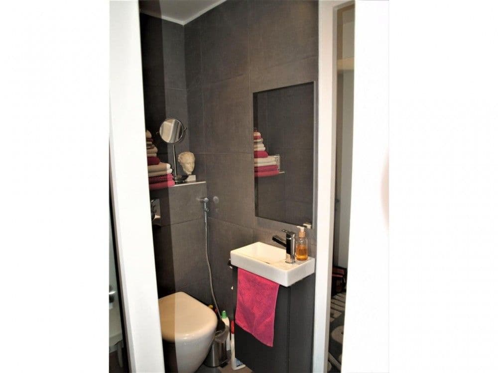 Shower room with dark tiles and wall-hung toilet, 2-bedroom apartment in the Carré d’Or, Nice