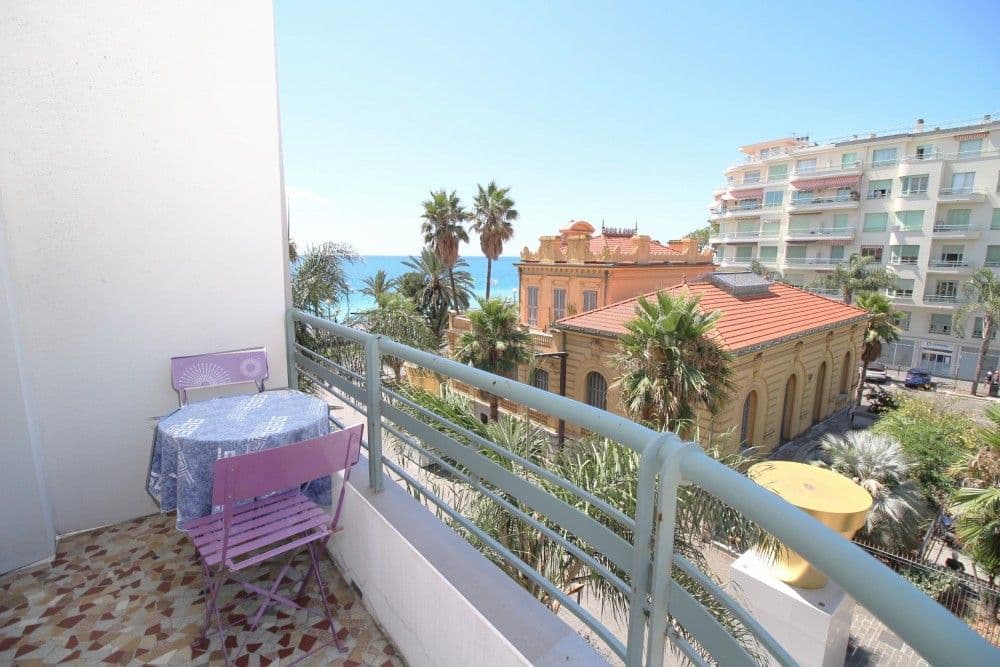 Balcony with bistro set overlooking palms and the sea, 2-bedroom apartment in the Promenade des Anglais, Nice
