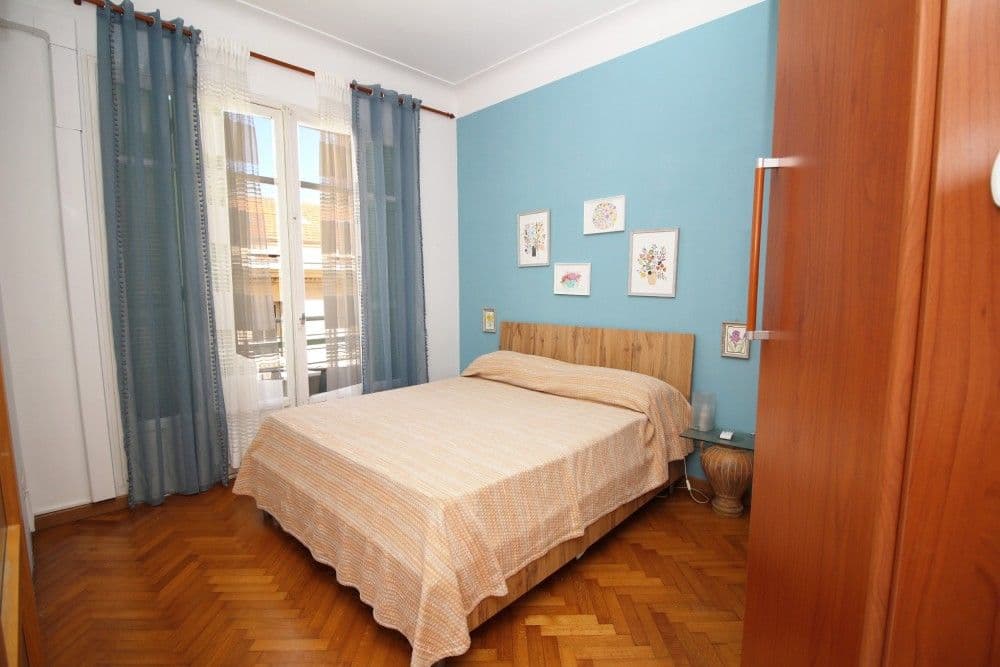 Bedroom with blue feature wall and parquet floor, 2-bedroom apartment in the Promenade des Anglais, Nice
