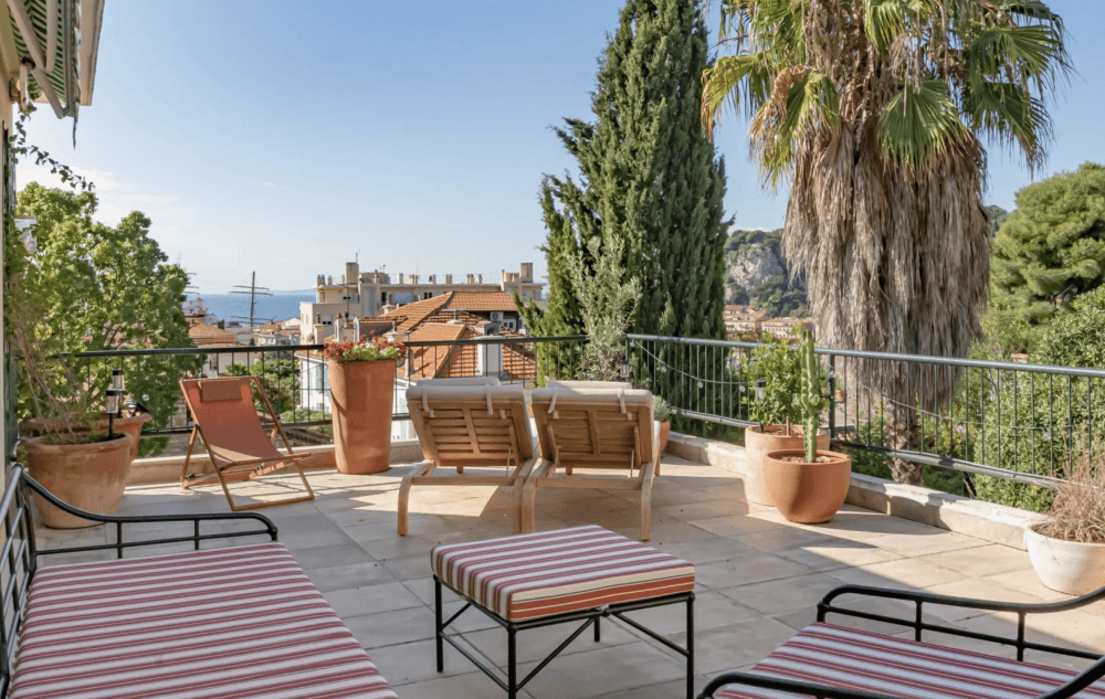 Large terrace with loungers, plants and a view of the sea and Castle Hill, 3-bedroom apartment in Mont Boron, Nice