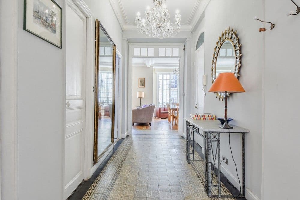 Hallway with cement tiles, chandelier and console table, 2-bedroom apartment in the Carré d’Or, Nice