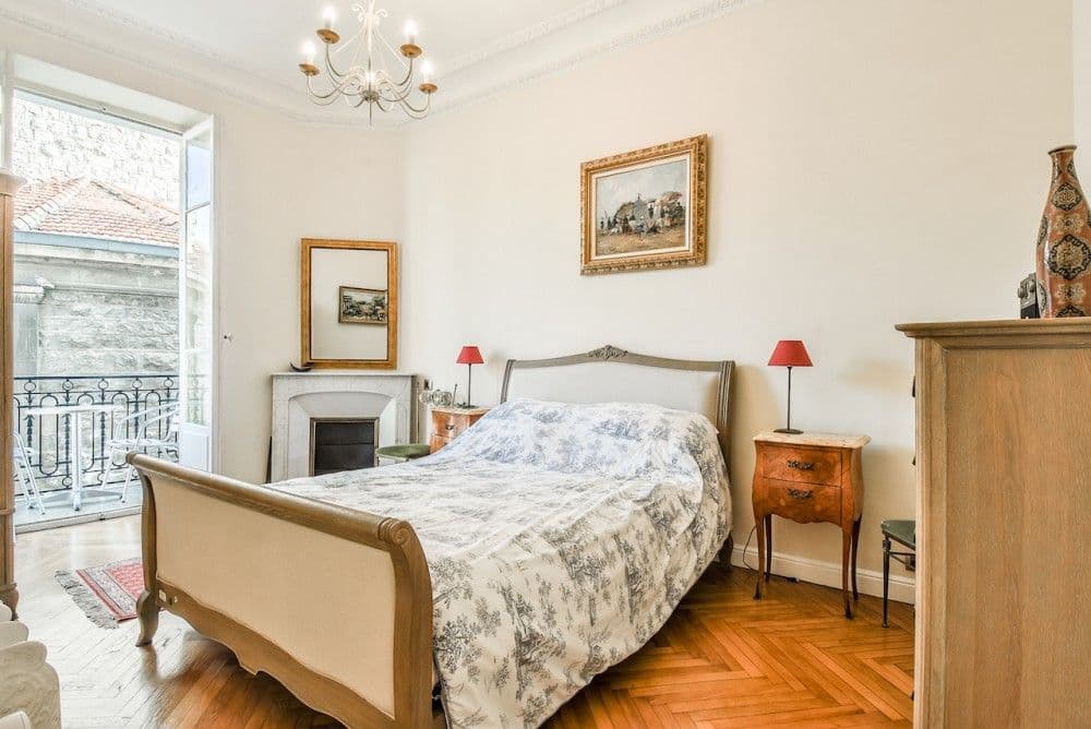 Bedroom with sleigh bed, marble fireplace and French window to a balcony, 2-bedroom apartment in the Carré d’Or, Nice