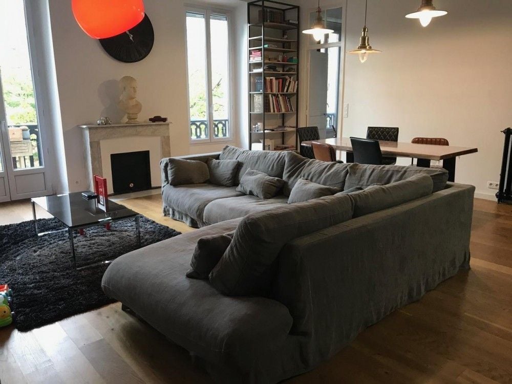 Living room with large sofa, marble fireplace and dining table, 2-bedroom apartment in central Nice