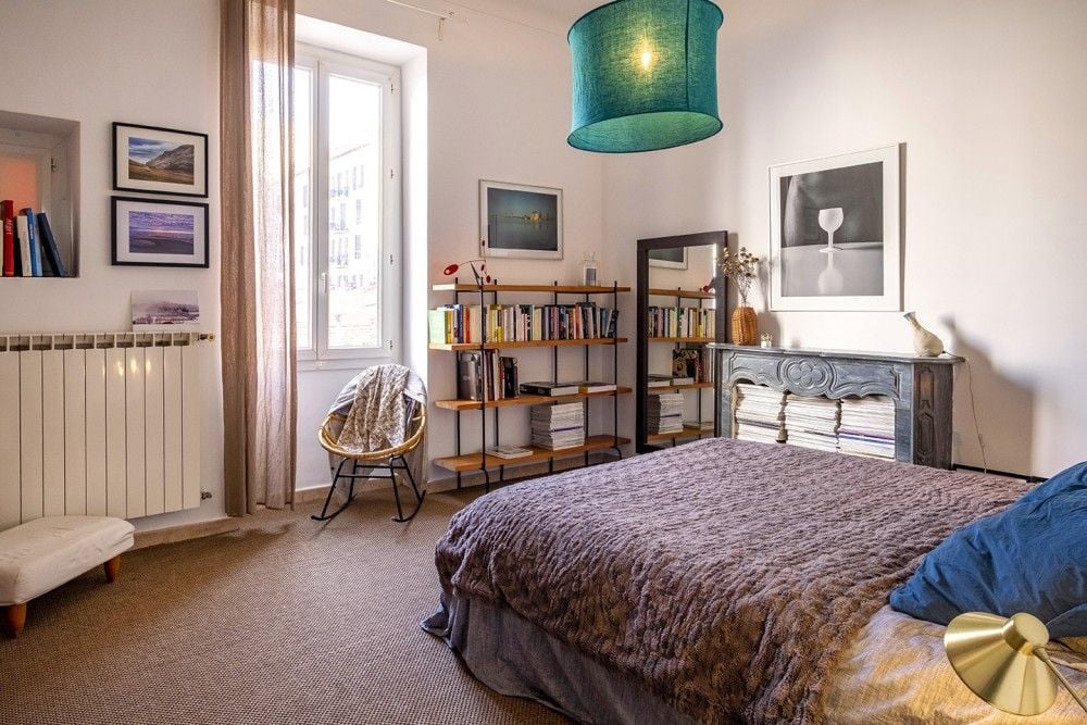 Bedroom with marble fireplace, bookshelves and tall window, 3-bedroom apartment in the Port, Nice