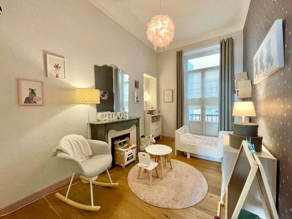 Child’s bedroom with marble fireplace and chandelier, 2-bedroom apartment in Nice