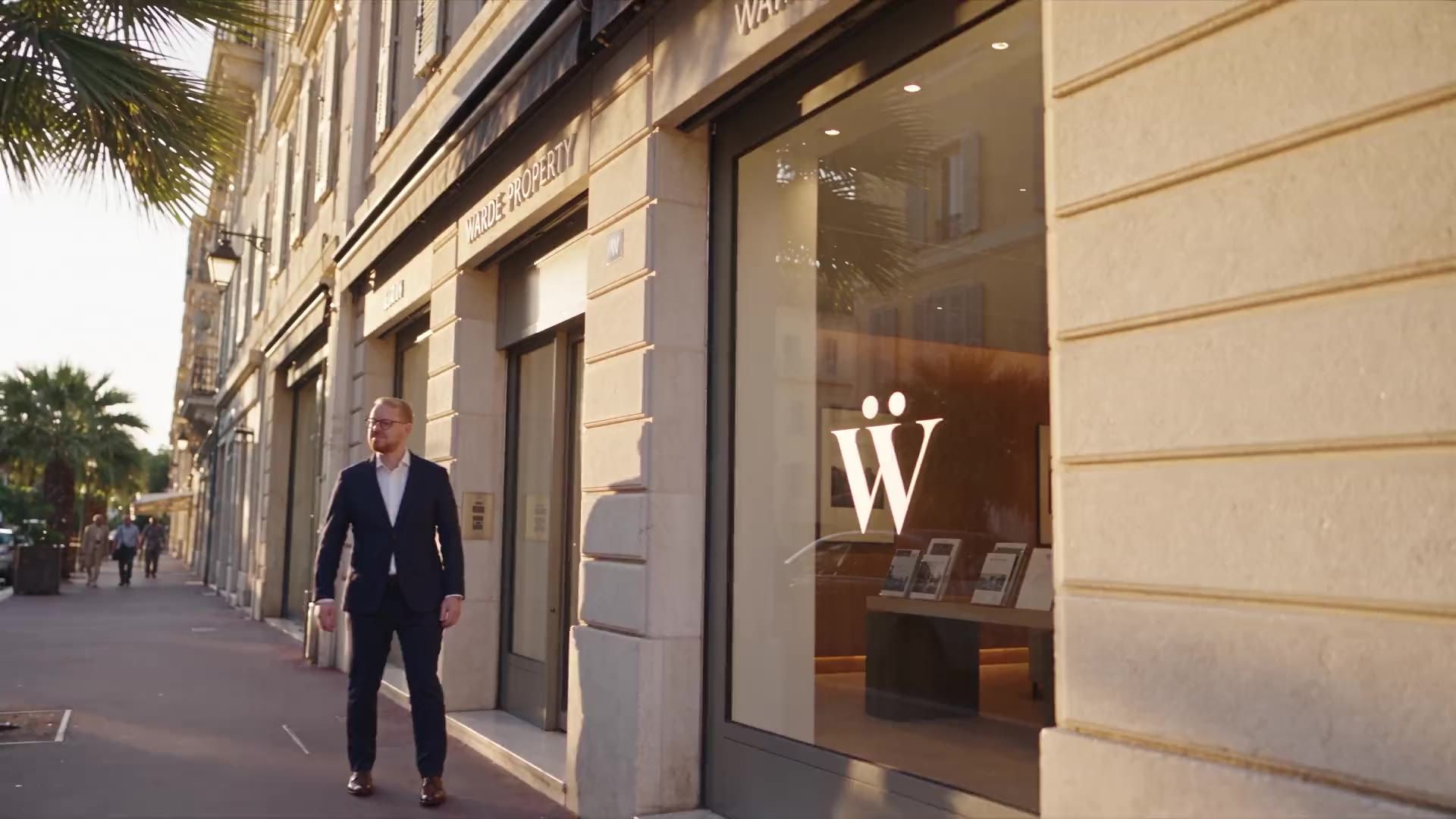 The Warde Property office front on a sunlit street lined with palm trees