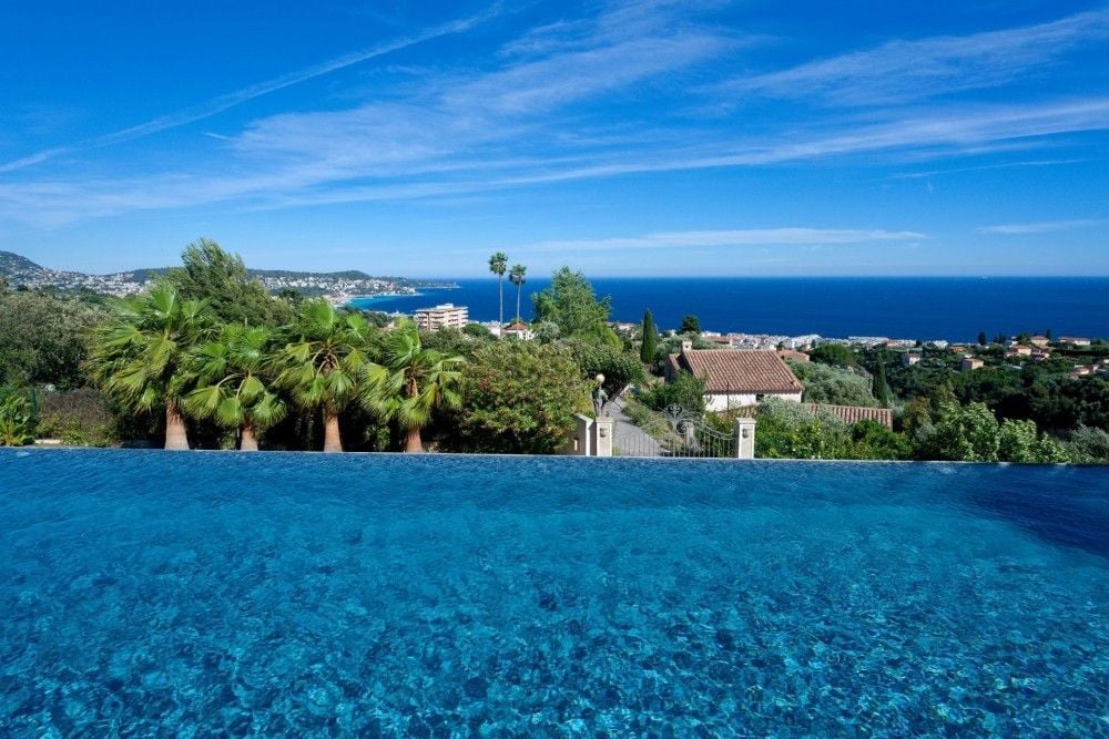 An infinity pool above the coast and the sea on the hill of Fabron