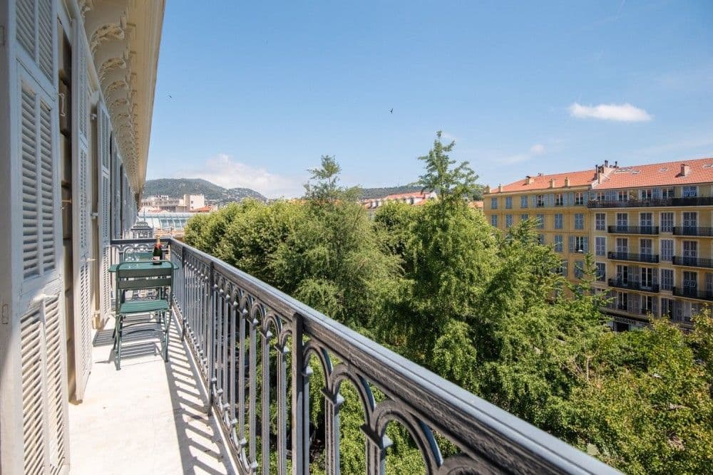 A wrought-iron balcony above the trees and façades of the Wilson quarter