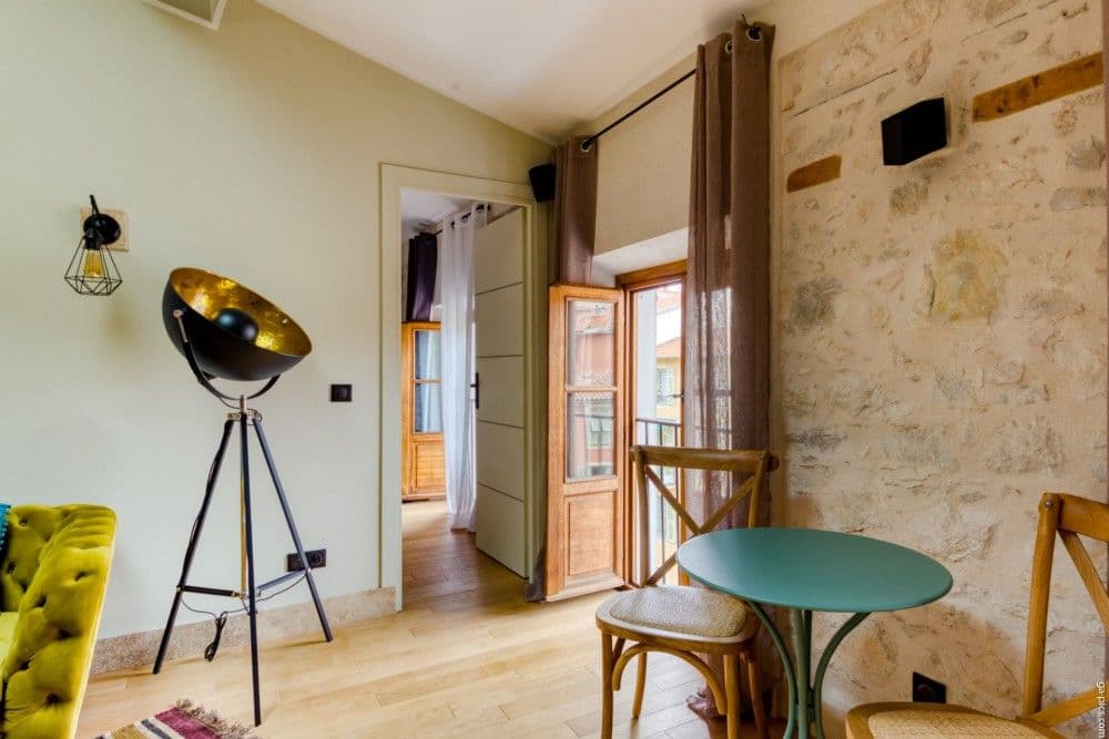 Sitting area with bistro table, exposed stone and French windows, 2-bedroom apartment in the Port, Nice