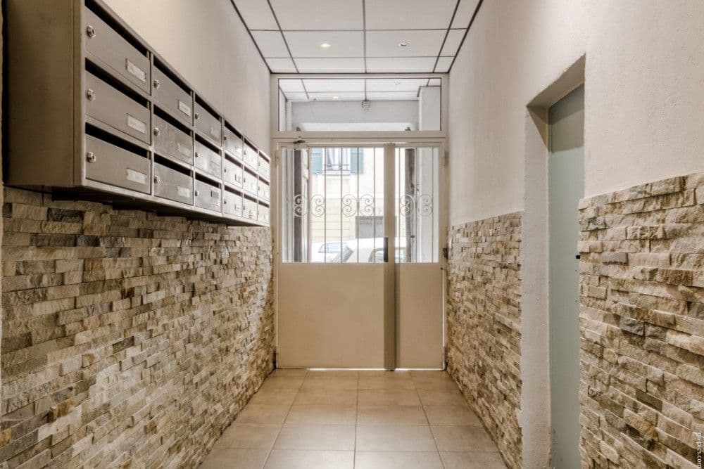 Building entrance hall with stone-clad walls and letterboxes, 2-bedroom apartment in the Port, Nice