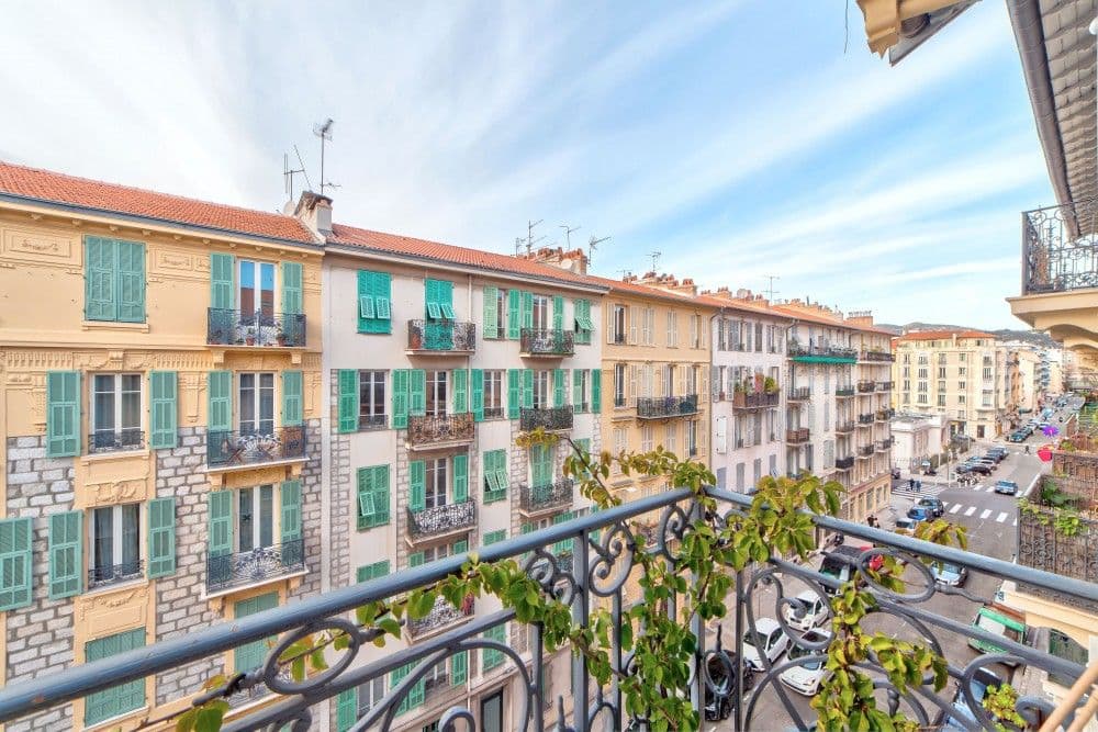 Balcony with wrought-iron railing and a view down a street of pastel façades, 2-bedroom apartment in the Port, Nice