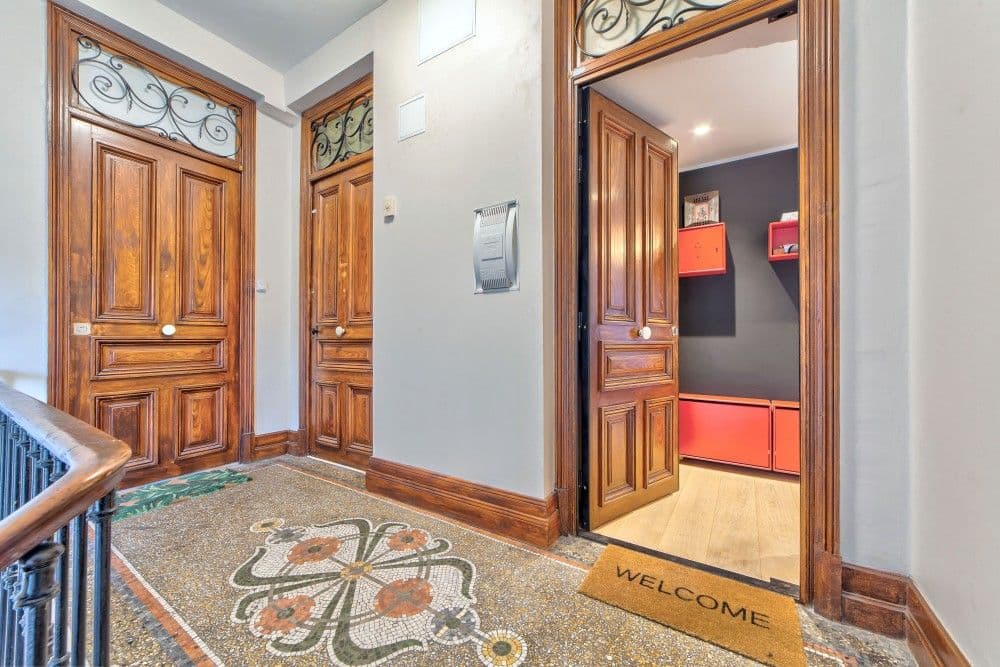 Landing with terrazzo floor and the apartment’s carved wooden door, 2-bedroom apartment in the Port, Nice