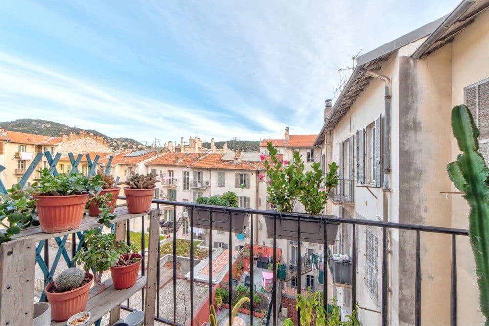 Balcony with plants and a view over the rooftops to the hills, 2-bedroom apartment in the Port, Nice