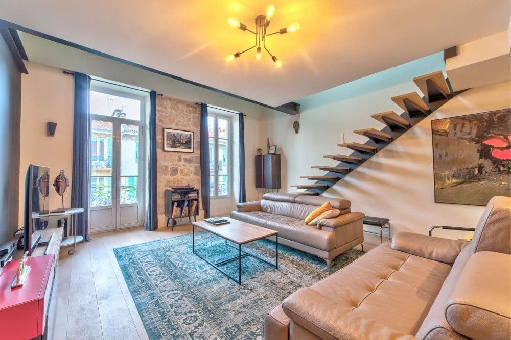 Living room with floating staircase, leather sofas and French windows, 2-bedroom apartment in the Port, Nice