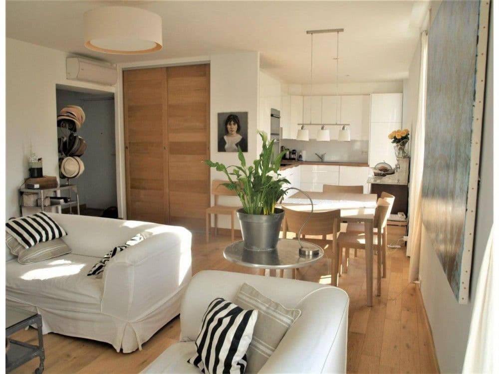 Living area with dining table and kitchen beyond, 2-bedroom apartment in the Carré d’Or, Nice