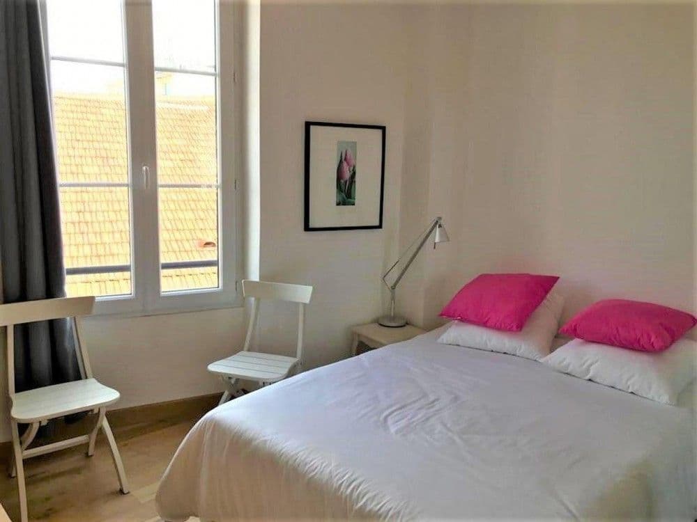 Bedroom with double bed and window over the rooftops, 2-bedroom apartment in the Carré d’Or, Nice