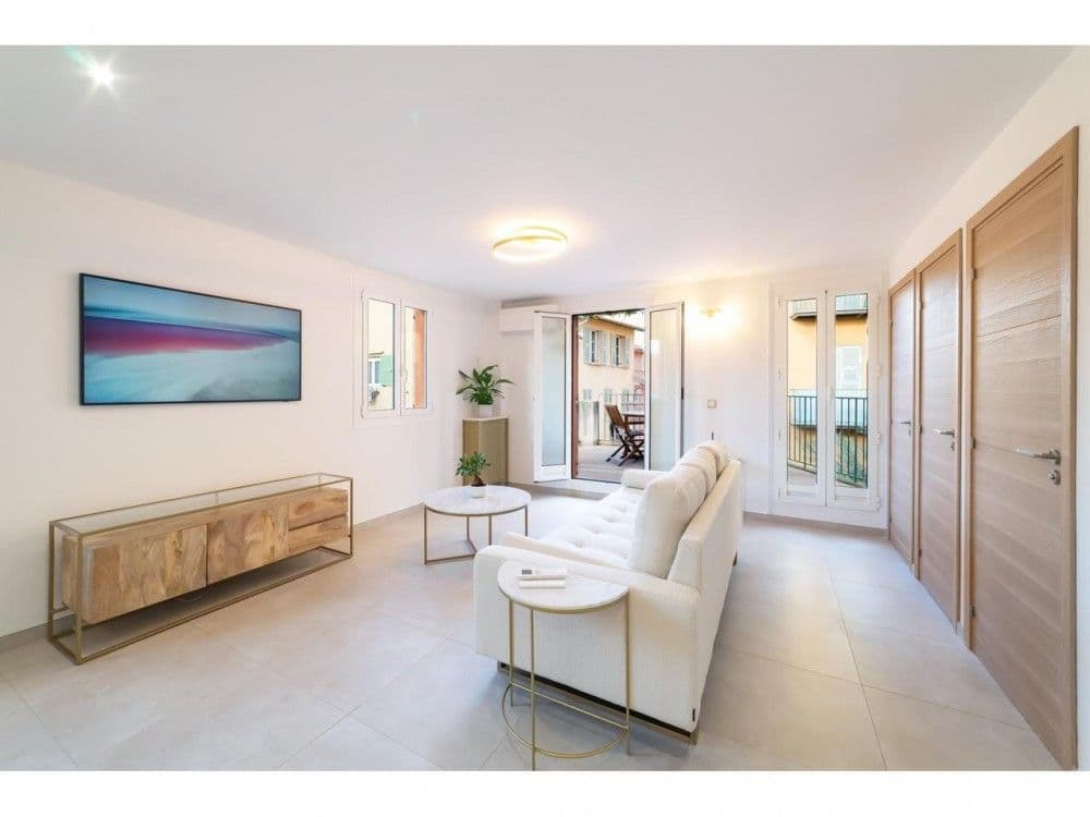 Living room with white sofa and French windows to the terrace, 2-bedroom apartment in the Old Town, Nice