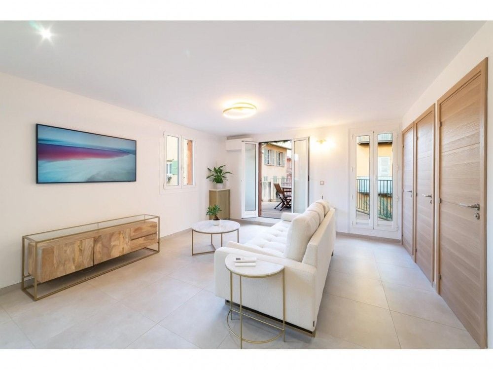 Living room with white sofa and French windows to the terrace, 2-bedroom apartment in the Old Town, Nice