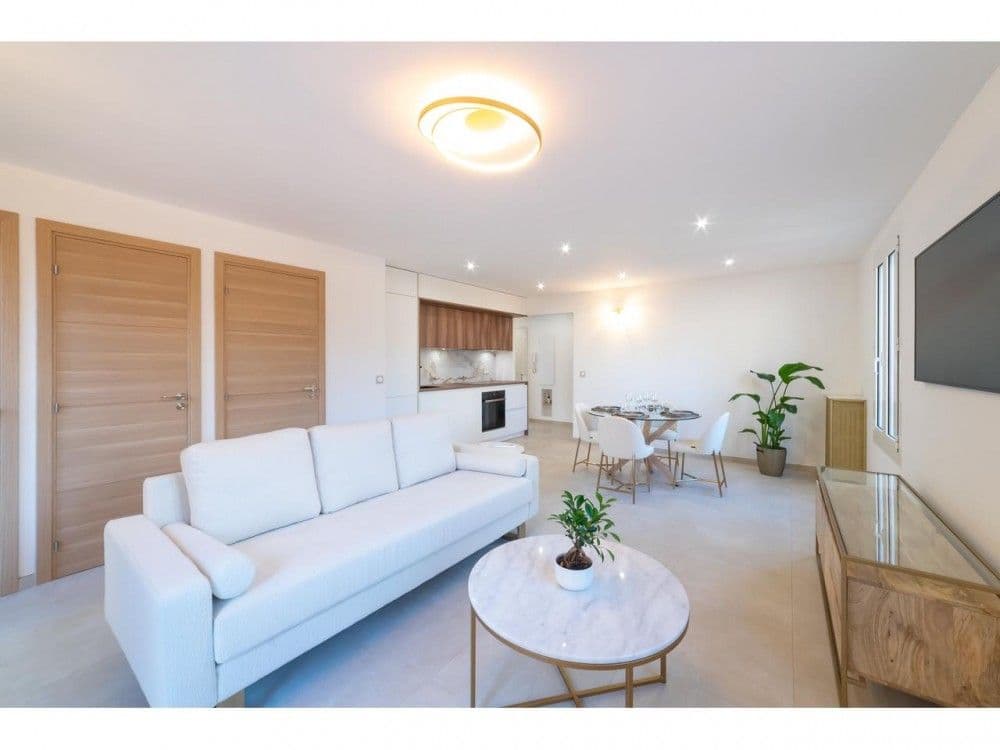 Living room with sofa, coffee table and open kitchen behind, 2-bedroom apartment in the Old Town, Nice