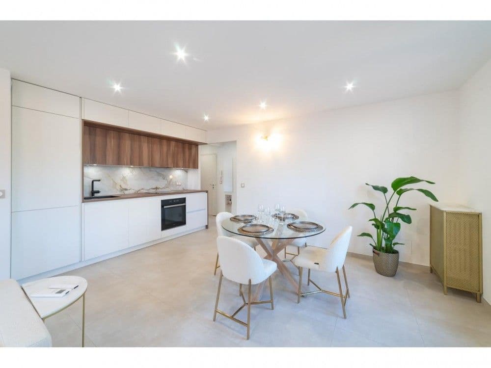Open-plan kitchen with white units and dining table, 2-bedroom apartment in the Old Town, Nice