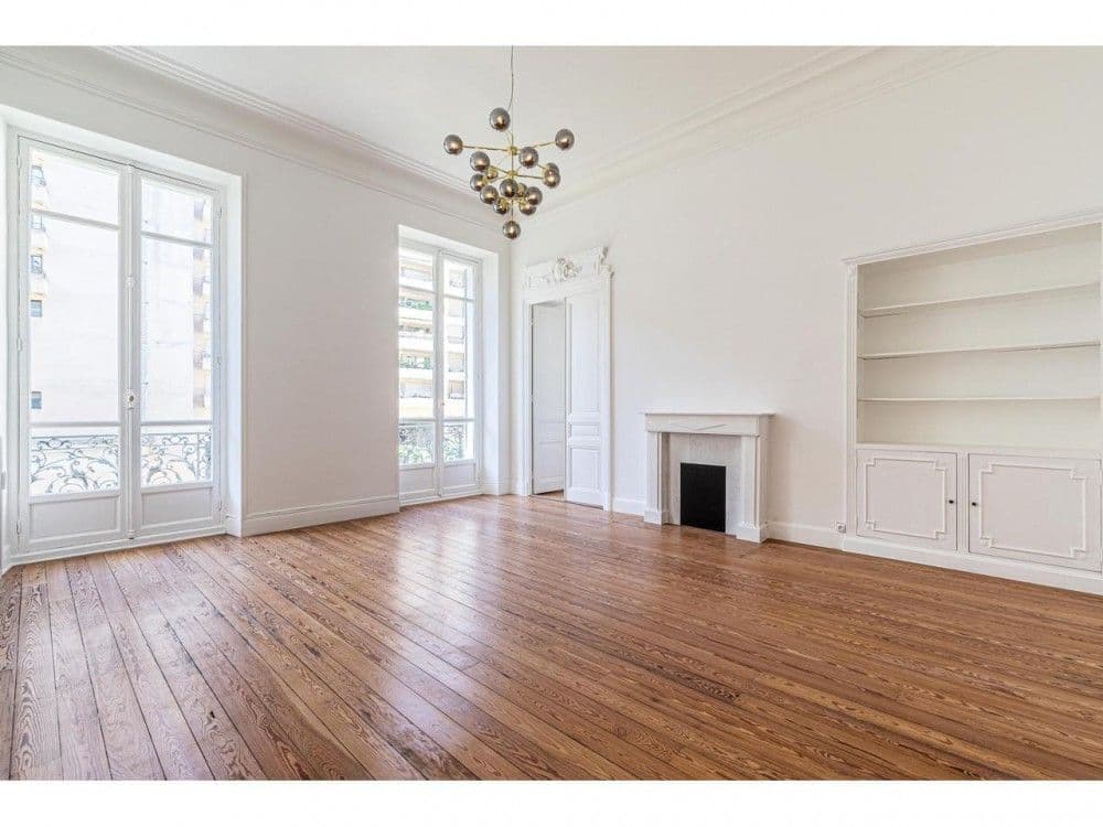 Living room with French windows, fireplace and built-in shelving, 3-bedroom apartment in the Carré d’Or, Nice
