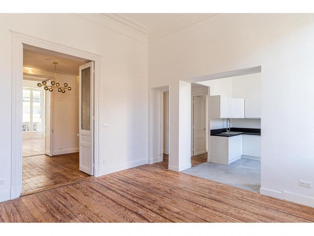 Living room opening onto a renovated kitchen, 3-bedroom apartment in the Carré d’Or, Nice