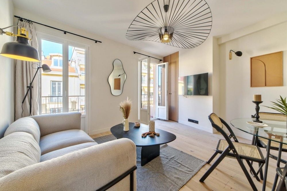 Renovated living room with oak floor and French windows to the balcony, 2-bedroom apartment in the Carré d’Or, Nice
