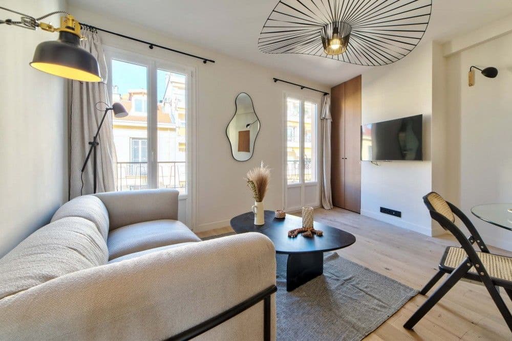 Living room with linen sofa, pendant light and French windows, 2-bedroom apartment in the Carré d’Or, Nice