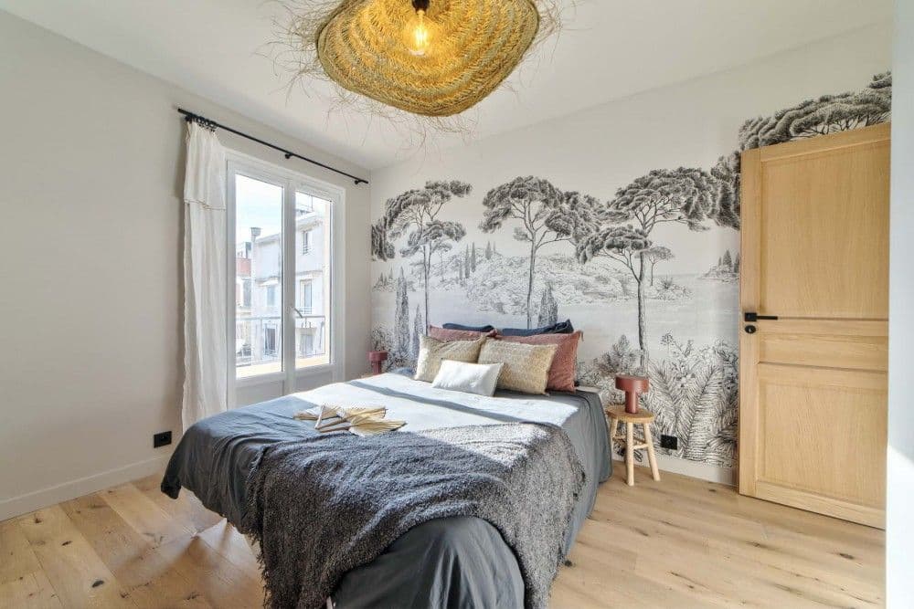 Bedroom with toile-style mural wallpaper and oak floor, 2-bedroom apartment in the Carré d’Or, Nice