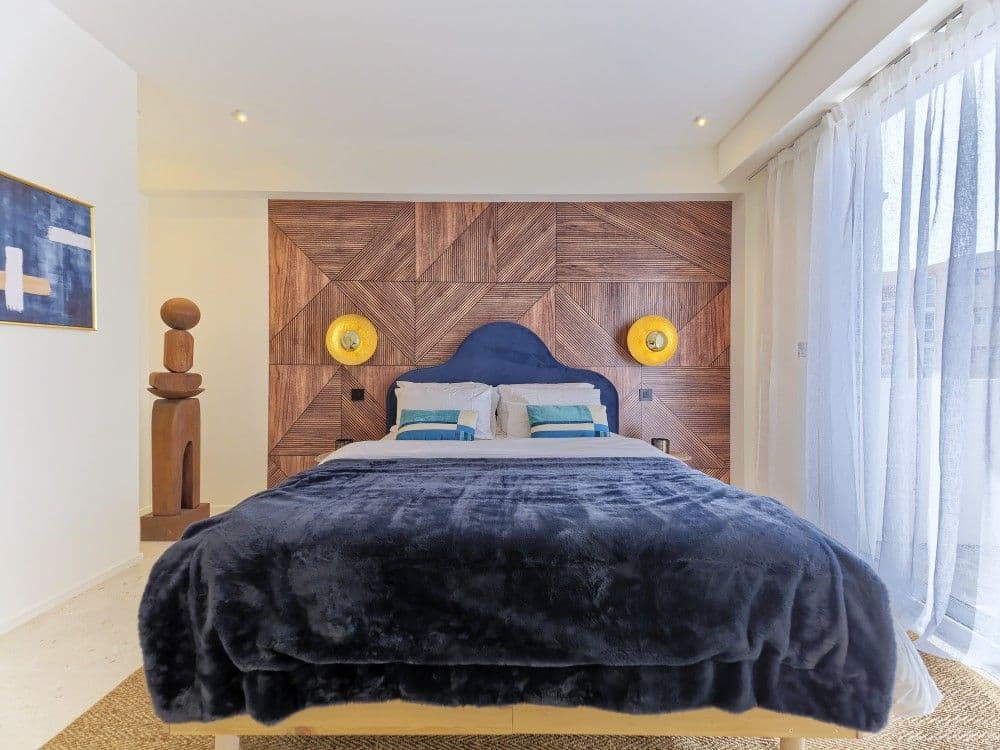 Bedroom with walnut headboard wall and velvet bed, 2-bedroom apartment in the Promenade des Anglais, Nice