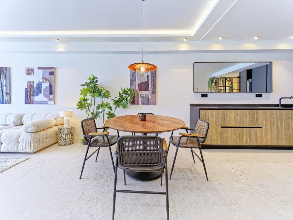 Dining area with round table and kitchen behind, 2-bedroom apartment in the Promenade des Anglais, Nice