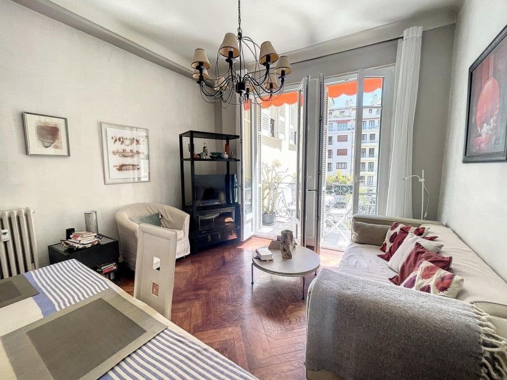 Living room with herringbone parquet, chandelier and French windows, 2-bedroom apartment in the Carré d’Or, Nice