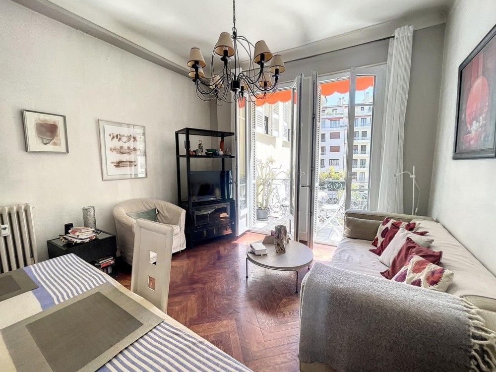 Living room with herringbone parquet, chandelier and French windows, 2-bedroom apartment in the Carré d’Or, Nice