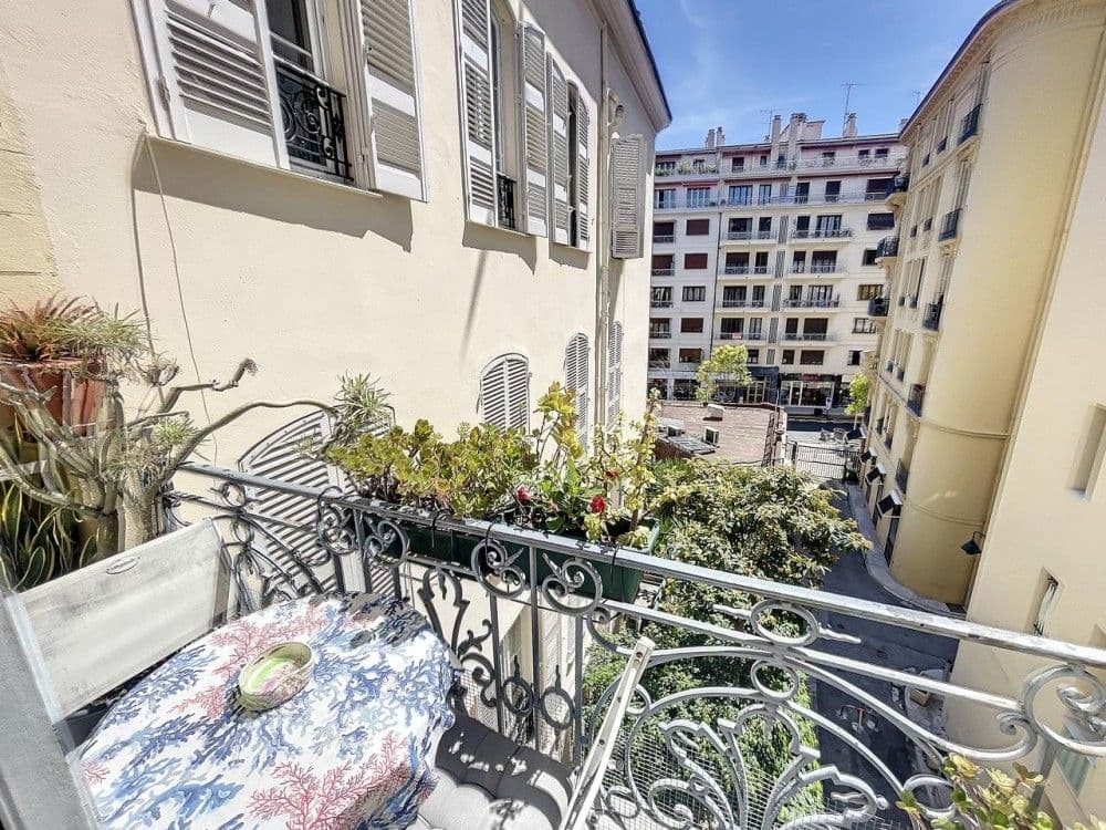 Balcony with plants and wrought-iron railing overlooking the street, 2-bedroom apartment in the Carré d’Or, Nice