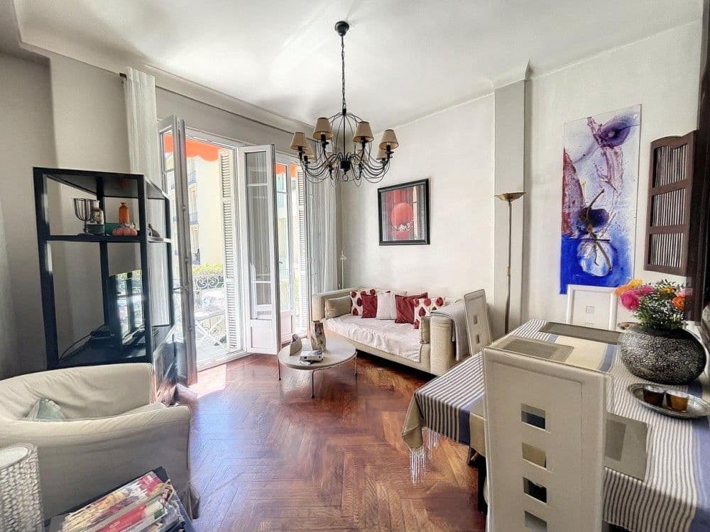 Living room with sofa, dining table and French windows, 2-bedroom apartment in the Carré d’Or, Nice