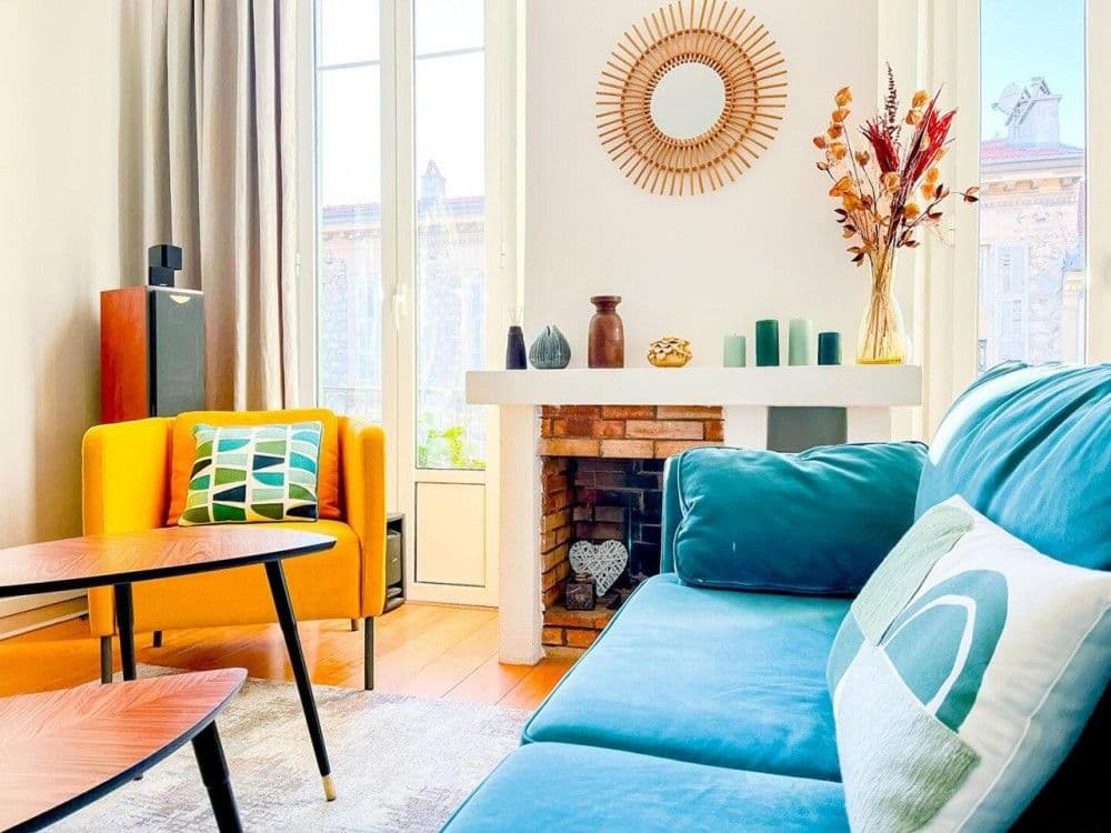 Sitting area with fireplace and blue sofa, 2-bedroom apartment in central Nice
