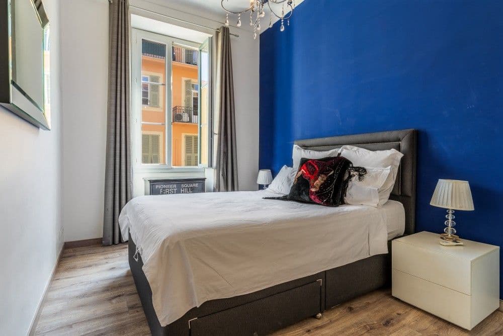 Bedroom with blue feature wall and chandelier, 2-bedroom apartment in the Port, Nice