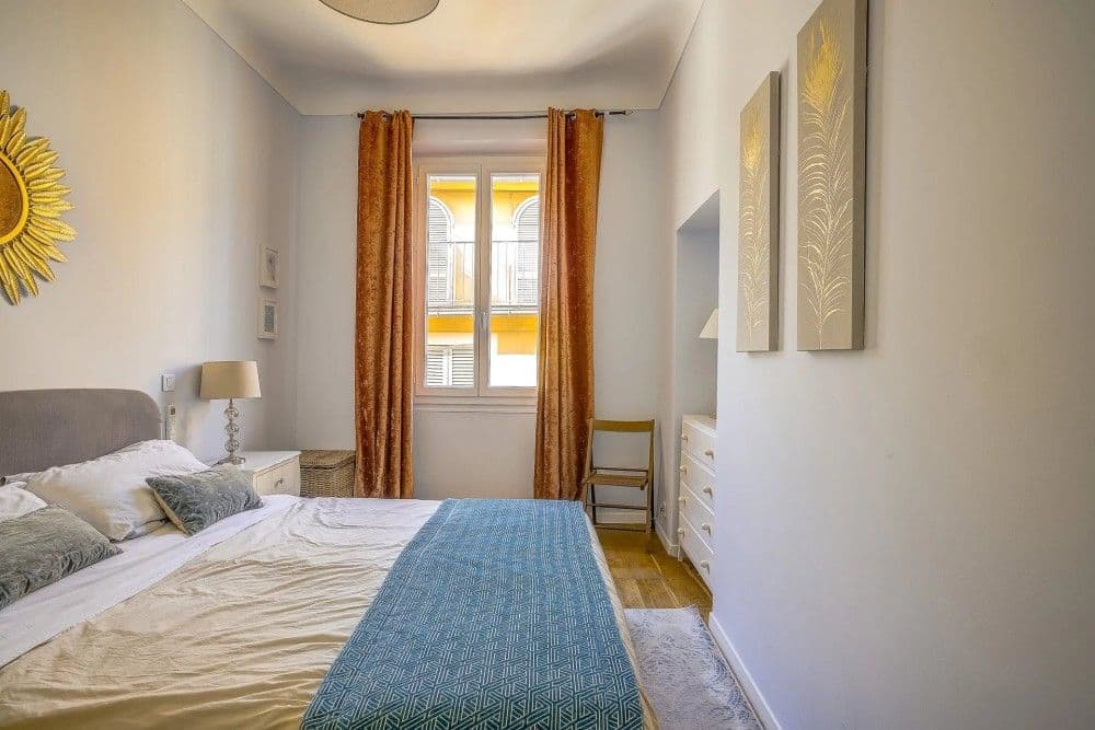 Bedroom with sunburst mirror and curtains, 2-bedroom apartment in the Old Town, Nice