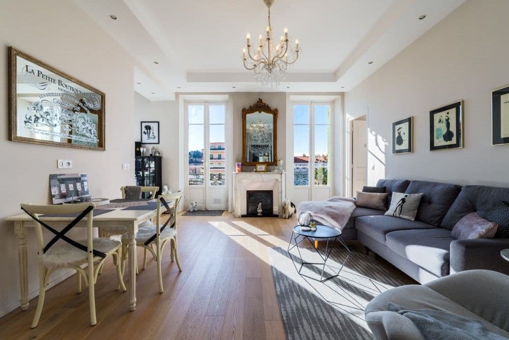 Living room with chandelier, fireplace and French windows, 2-bedroom apartment in central Nice