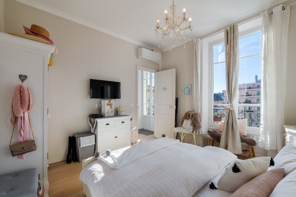 Bedroom with chandelier and tall windows, 2-bedroom apartment in central Nice