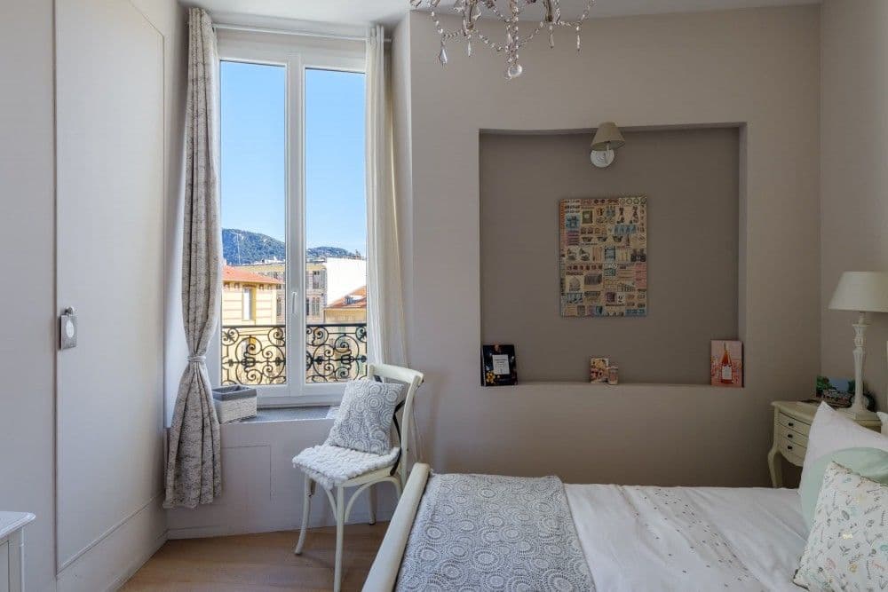 Bedroom with tall window and wrought-iron railing, 2-bedroom apartment in central Nice