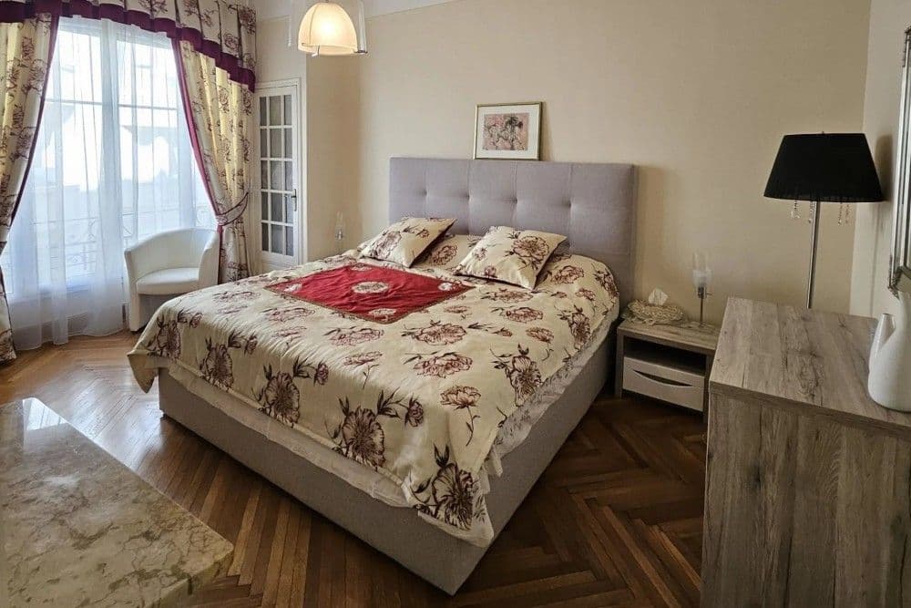 Bedroom with upholstered headboard and herringbone parquet, 3-bedroom apartment in the Promenade des Anglais, Nice