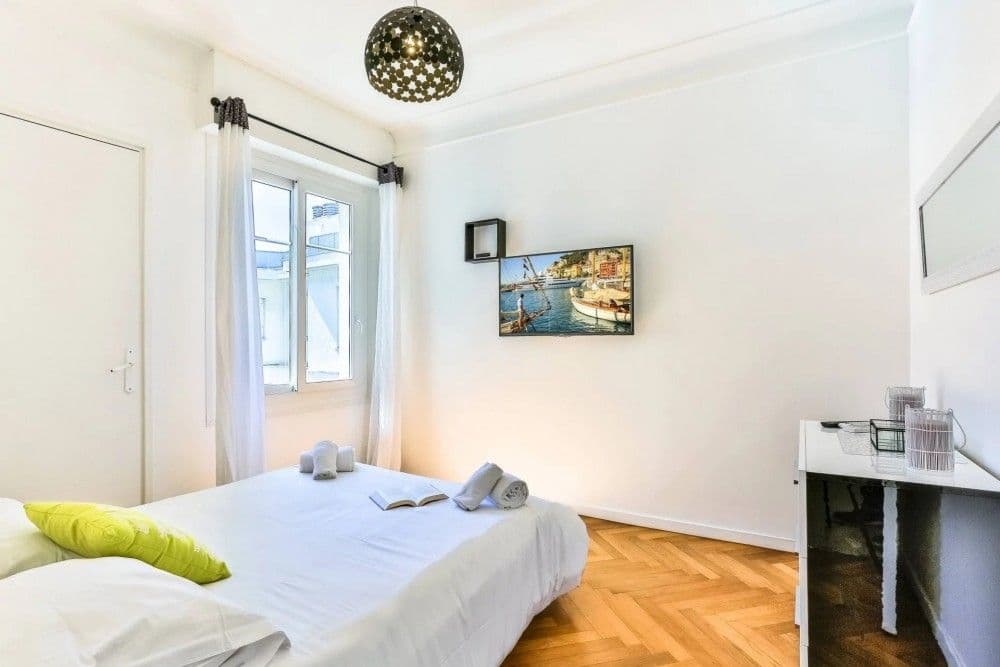 Bedroom with herringbone parquet and window, 2-bedroom apartment in the Promenade des Anglais, Nice