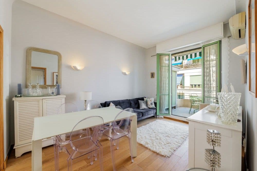 Living and dining room with wooden floor and doors to the balcony, 1-bedroom apartment in central Nice