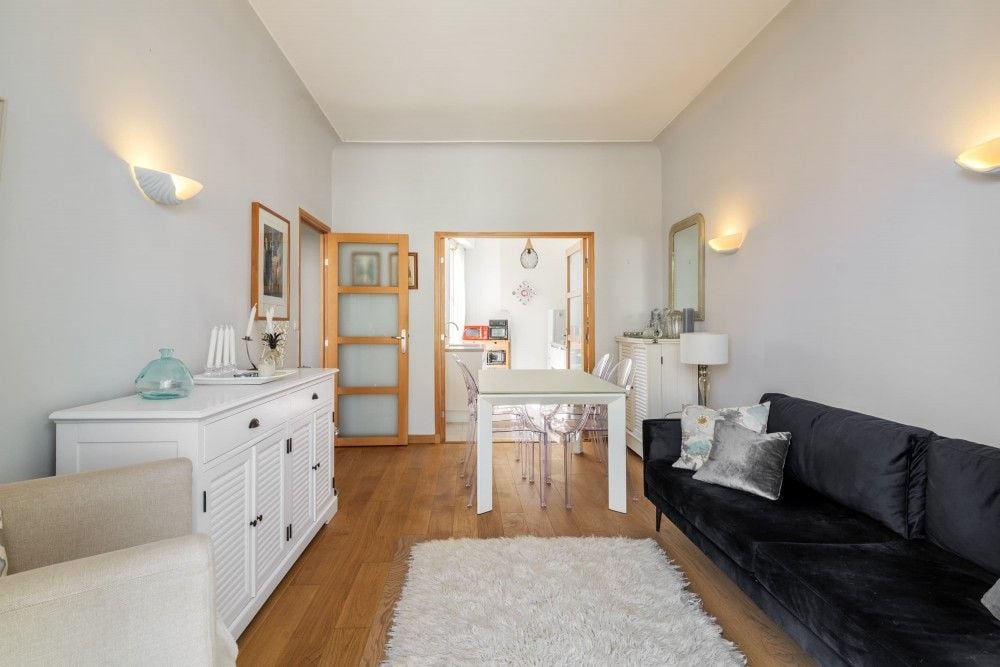 Living room with black sofa and dining table, 1-bedroom apartment in central Nice